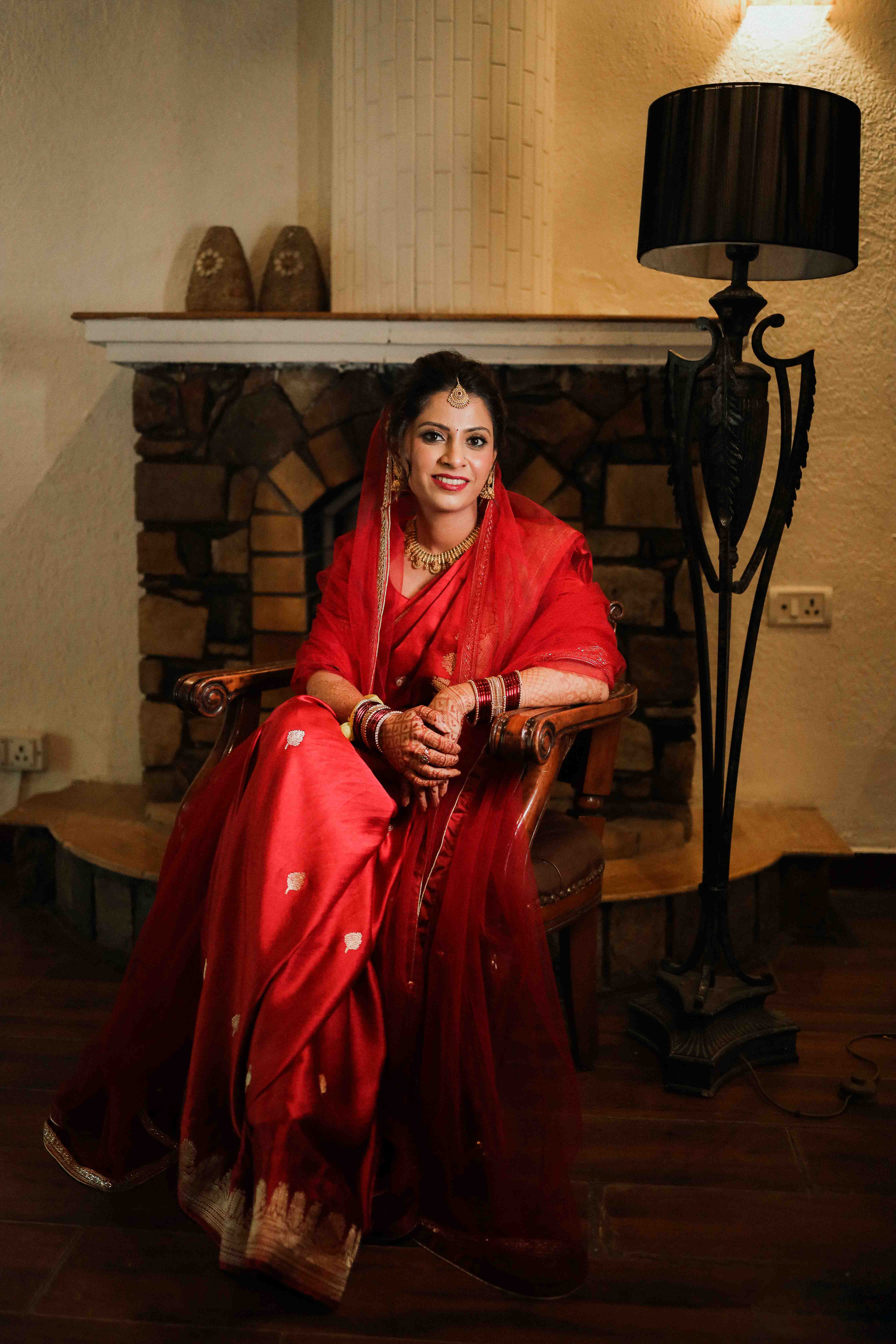 A couple in traditional Indian attire standing in front of an ornate doorway